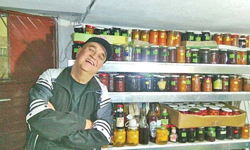 Cămara lui este plină de conserve: suc de roşii, dulceaţă, gem