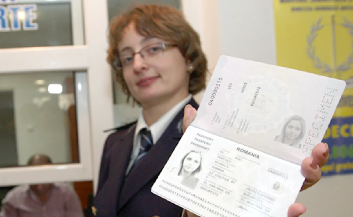 O angajată a Serviciului Paşapoarte prezintă noul act de identitate