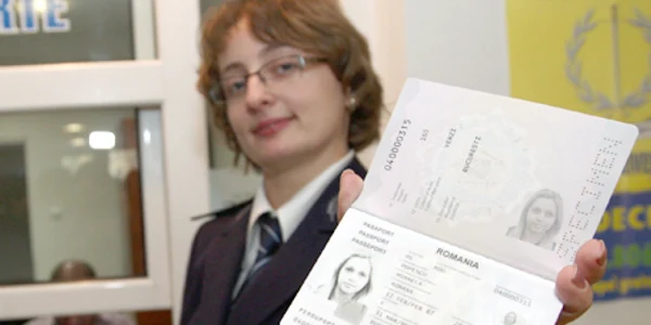 O angajată a Serviciului Paşapoarte prezintă noul act de identitate