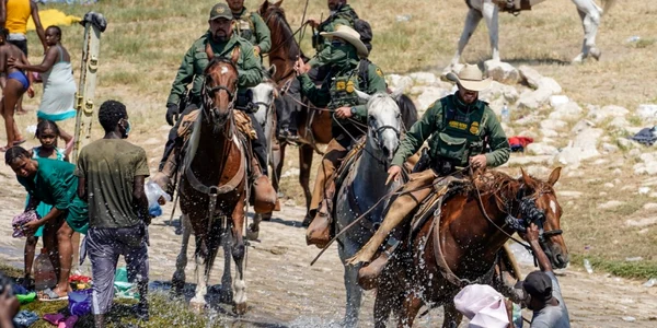 Agenti de poliţie de frontieră din Statelor Unite călare încearcă să opreasca un migranti haitian să intre într-o tabără pe malurile Rio Grande in Del Rio Texas