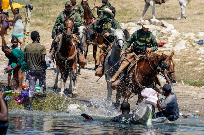 Agenti de poliţie de frontieră din Statelor Unite călare încearcă să opreasca migrantii haitieni să intre într-o tabără pe malurile Rio Grande in Del Rio Texas pe 19 septembrie 2021 FOTO AFP / Paul Ratje