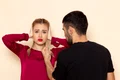 front view young female red shirt suffers from physical threats violence with shut ears cream space female cloth photo jpg