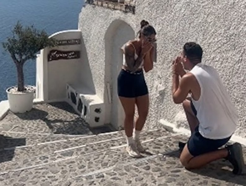 Romantična zaroka v Santoriniju se je spremenila v viralno senzacijo zaradi nepričakovanih vmešavanj