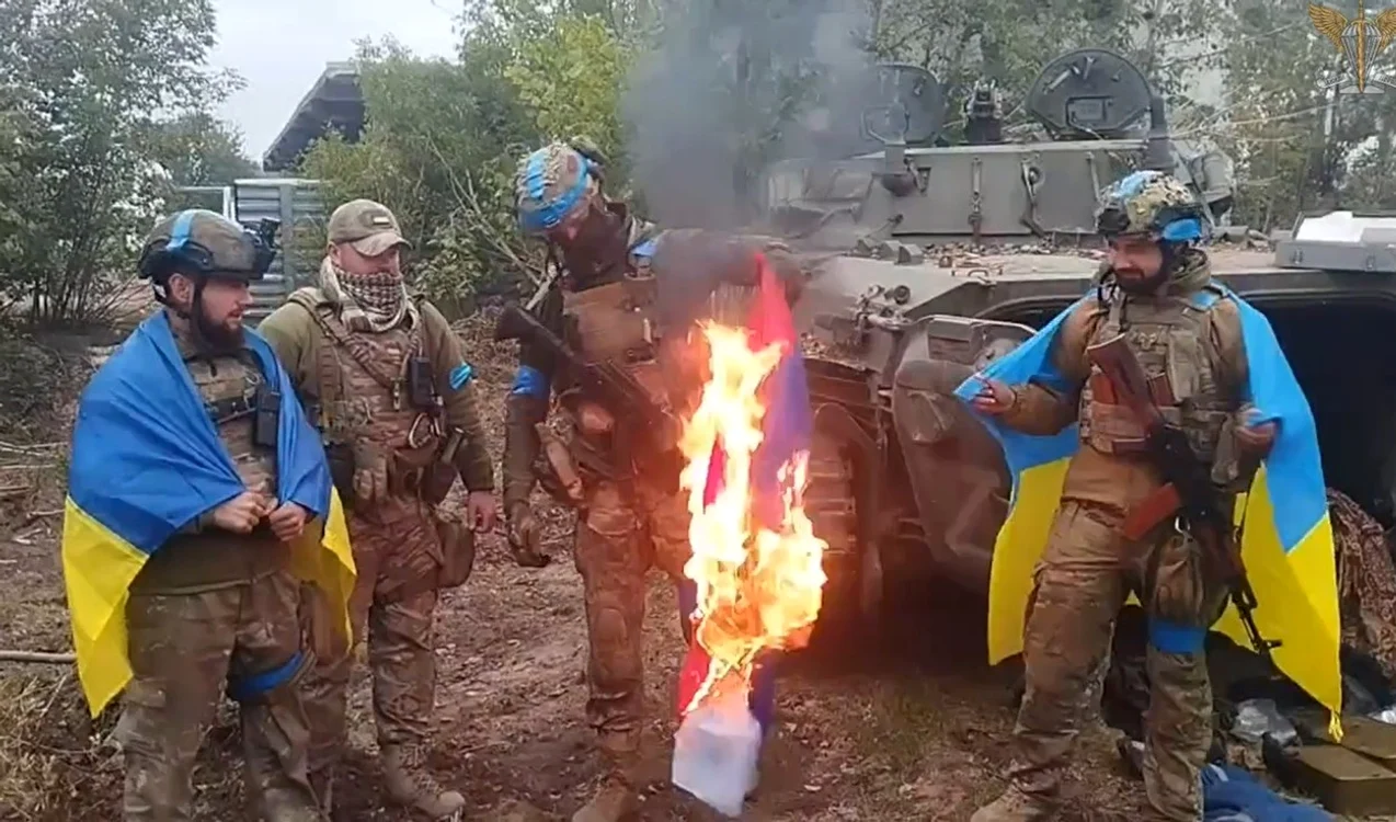 Soldați ucraineni care au eliberat orașe de sub ruși ard un steag rusesc FOTO Profimedia