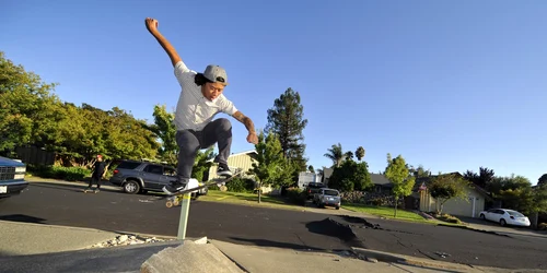 Un băiat se dă cu skateboard-ul pe o stradă pe care pavajul s-a ridicat din cauza unui cutremur