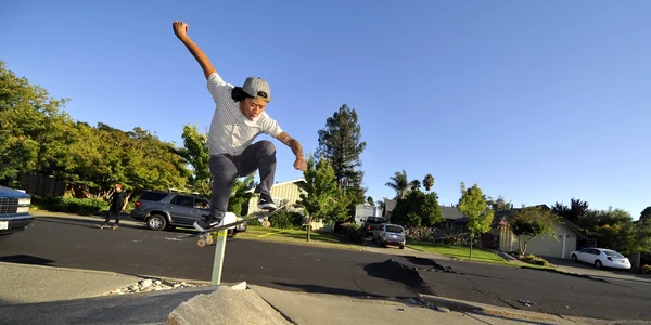 Un băiat se dă cu skateboard-ul pe o stradă pe care pavajul s-a ridicat din cauza unui cutremur