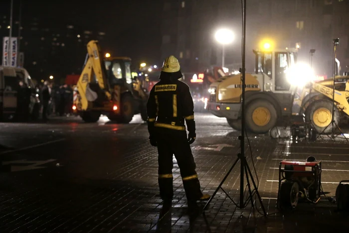 Un pompier leton urmăreşte operaţiunea de salvare de la supermarketul Maxima. FOTO: Reuters