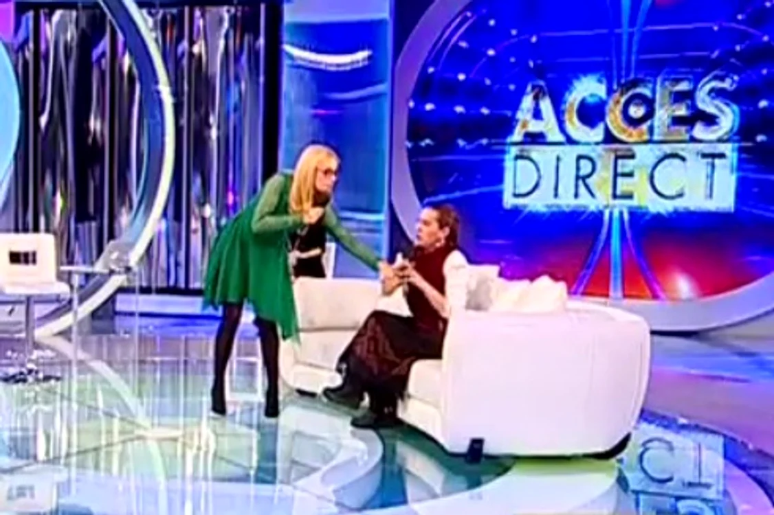 Simona s-a dus până la canapea, unde stătea Angelica, şi aproape că i-a smuls microfonul din mână