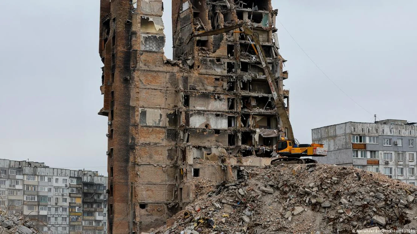 Un excavator demolează o casă distrusă la Mariupol (martie 2023)