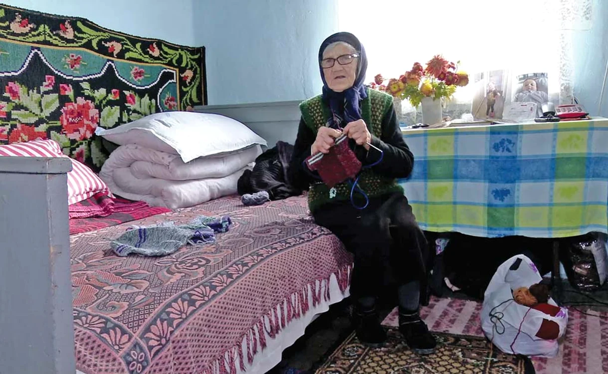 Bătrâna tricotează hăinuţe pentru strănepoţi