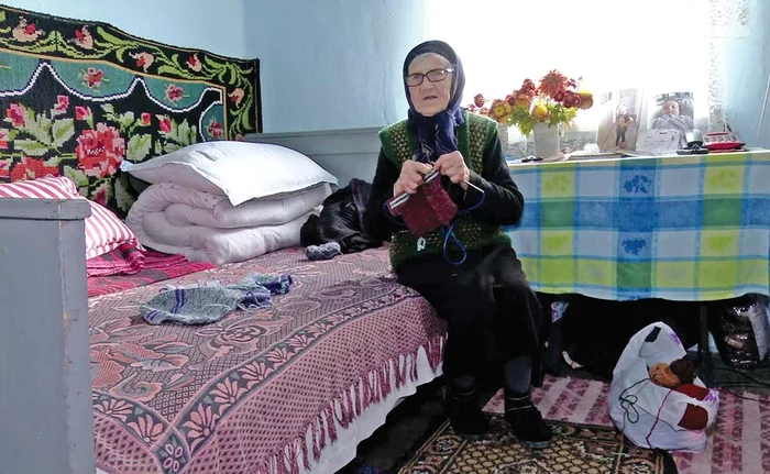 Bătrâna tricotează hăinuţe pentru strănepoţi