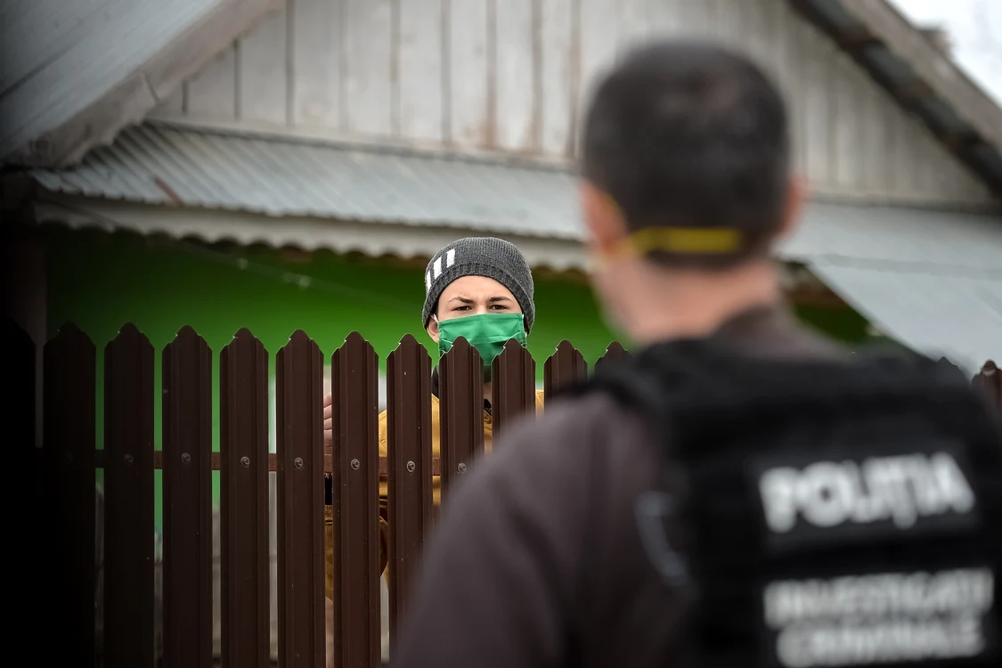 Un copil vorbește cu un polițist peste gard