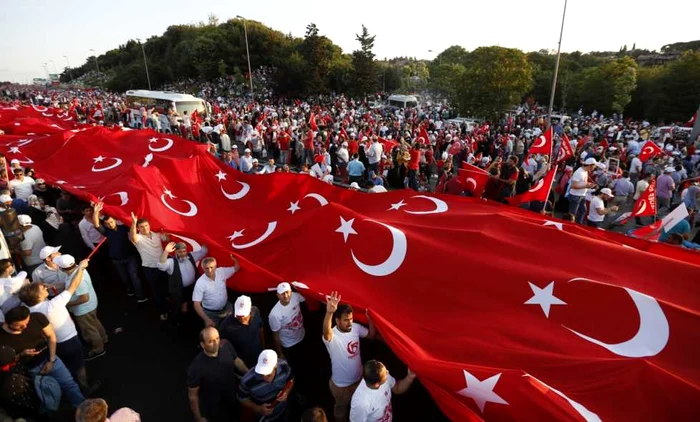 Oamenii deţin un steag imens turcesc la un miting pentru prima aniversare după încercarea eşuată de înlăturare a preşedintelui turc Recep Tayyip Erdogan în Istanbul Turcia FOTO EPA Erdem Sahin 