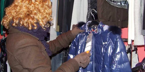 O tânără studiază cu atenţie preţul unei geci de iarnă.