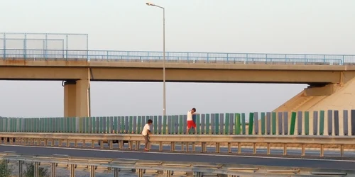 Copii escaladând gardul de pe Autostrada Soarelui