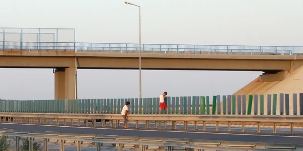 Copii escaladând gardul de pe Autostrada Soarelui