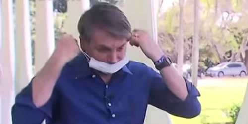 Jair Bolsonaro isi da masca jos in fata unor jurnalisti Captura YouTube/ The Guardian