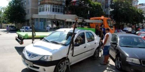 Şoferii trebuie să plătească taxa de parcare pentru a nu le fi blocate roţile sau ridicată maşina
