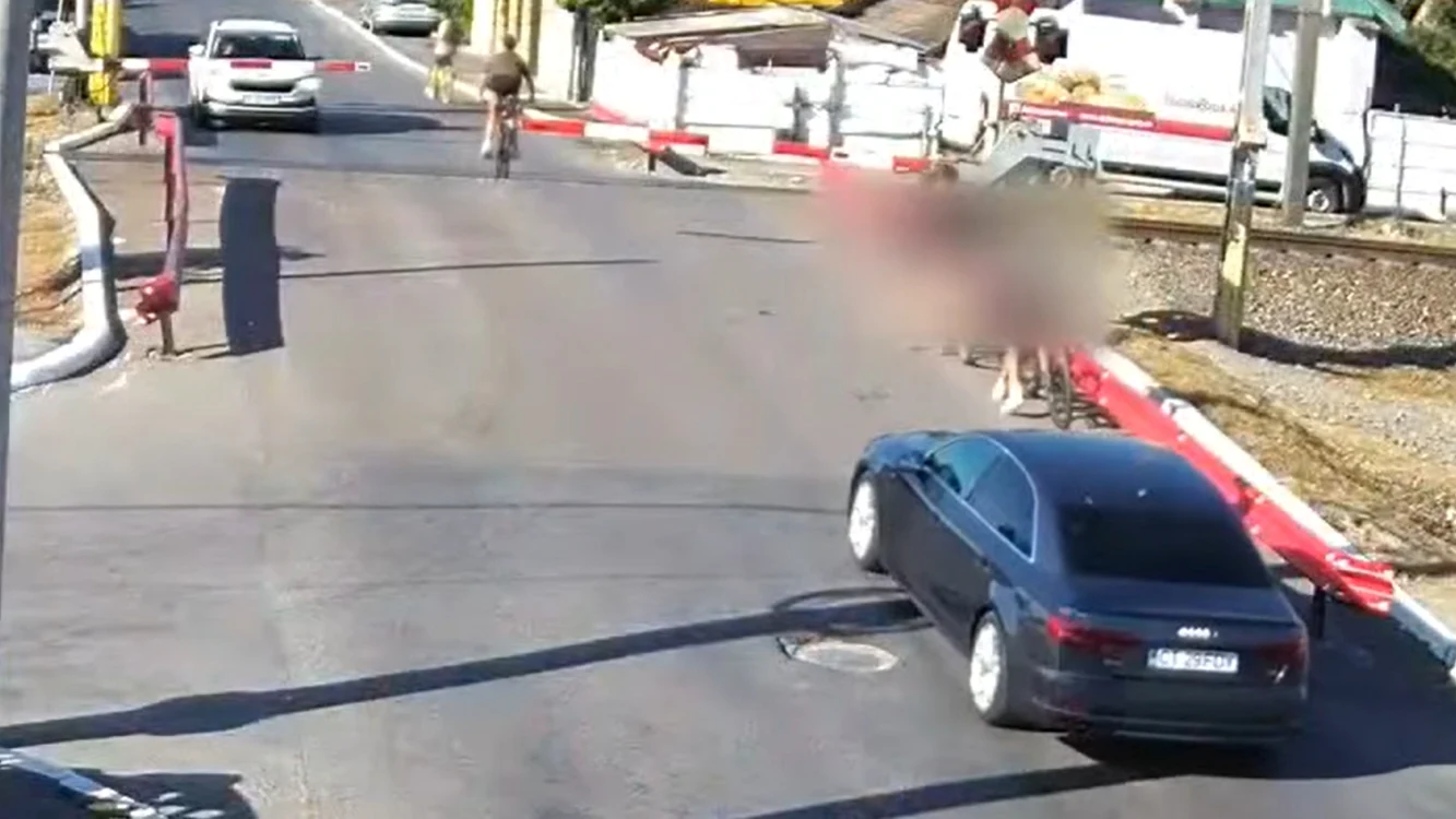 Momentul în care cei doi copii trec pe lângă barierele coborâte 