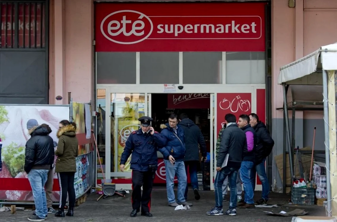 Trecători strânşi în faţa supermarketului jefuit. FOTO La Repubblica