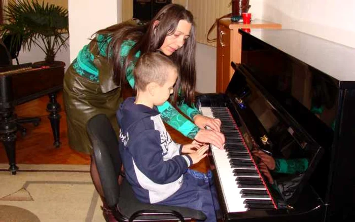 Elisabeta Georgescu cu unul dintre elevii care studiază pianul