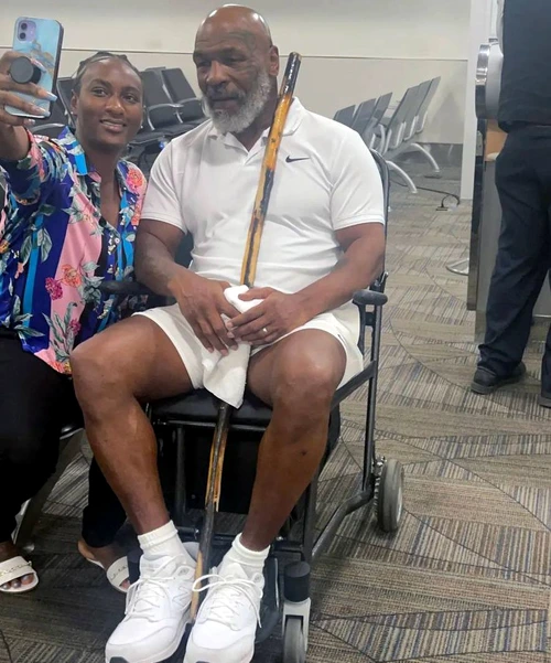 Mike Tyson stă în scaunul cu rotile și are la îndemână un baston. Foto Twitter