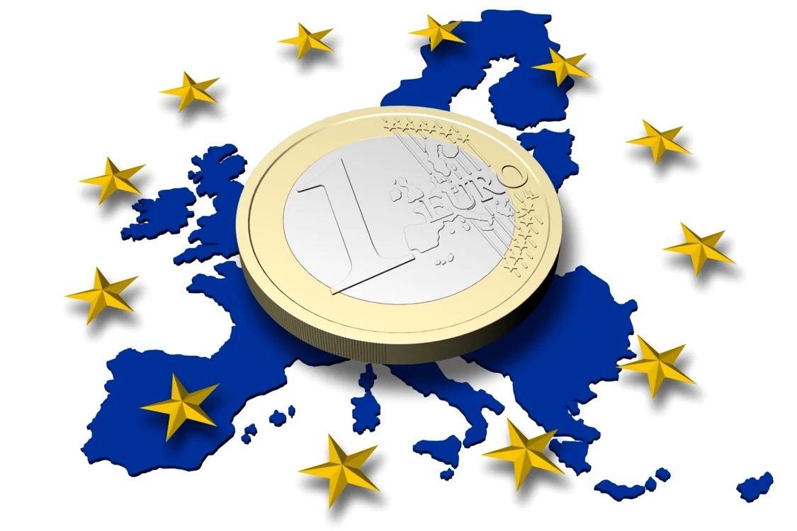 O monedă de 1 euro peste harta Europei colorată în albastru și înconjurată se steluțe aurii