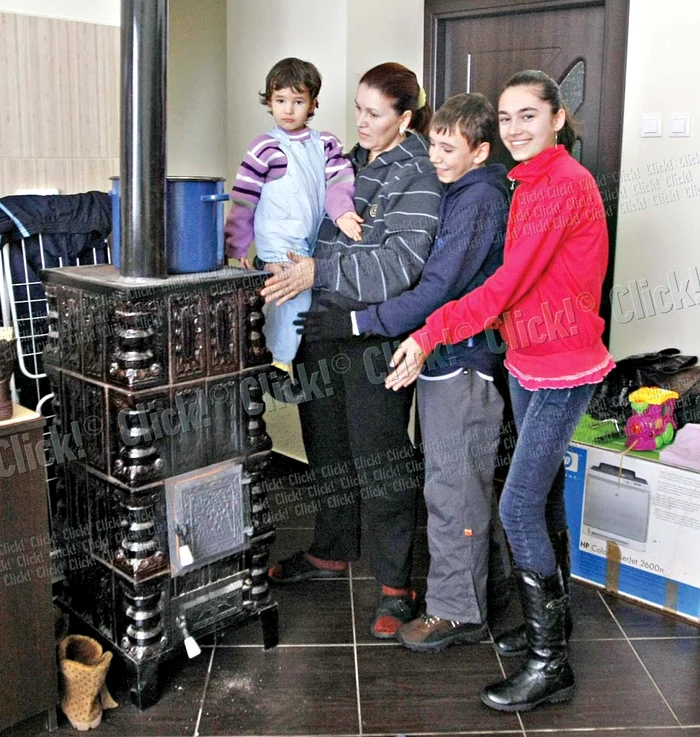
    Laura Pavel şi cei trei copii  se încălzesc la sobă  pentru că nu au gaze (Fotografii: Dan Bistriţeanu)  
