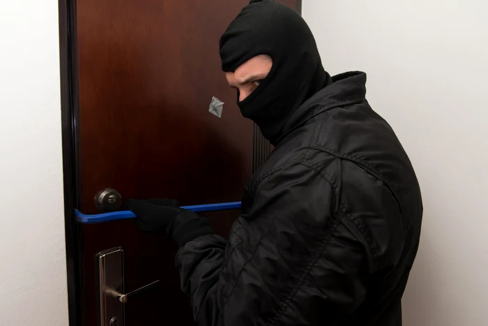 Spărgătorul foloseşte  ranga pentru  deschiderea uşilor. FOTO: Profimedia