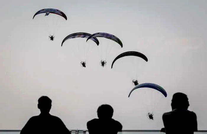 Turiştii urmăresc parapantele în timpul Heavens Gate Paramotor Air Games în Zhang Jiajie provincia Hunan China FOTO Guliver Getty Images Wang He