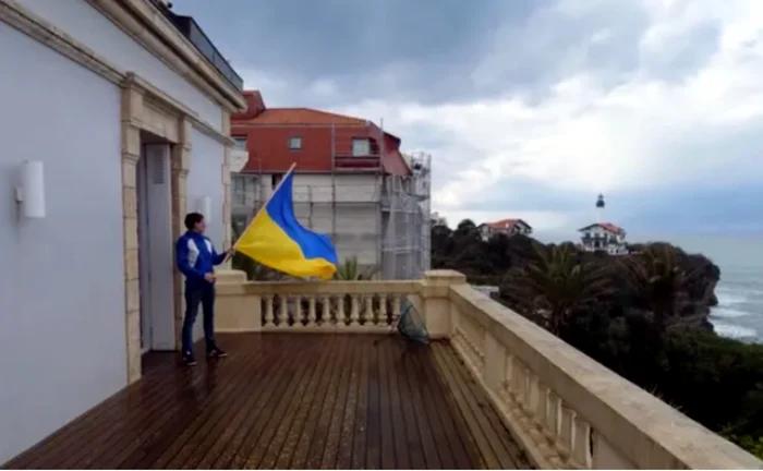 Activist rus cu steagul ucrainean la balconul proprietăţii unui oligarh FOTO via The Guardian