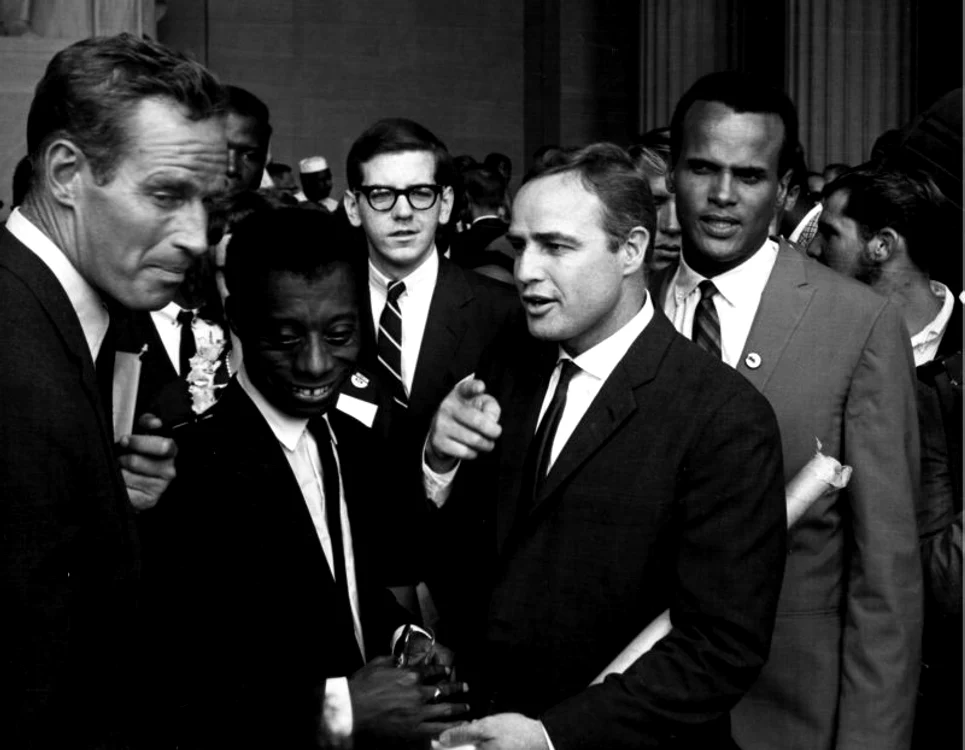 Între cei care au ascultat discursul lui Martin Luther King Jr. s-au aflat şi actorul Charlton Heston (stânga),  scriitorul James Baldwin,  actorul Marlon Brando,  cântăreţul Harry Belafonte (dreapta)