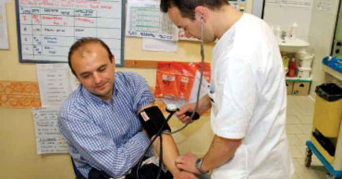 Un medic ia tensiunea unui bărvbat în cabinetul medical