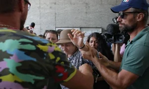 Copiii femeii i au dat la o parte pe ziariștii și cameramanii aflați la sediul central DIICOT, pentru a putea intra în clădire jpeg