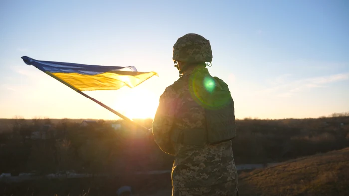 Soldat ucrainean flutură steagul țării sale FOTO SHUTTERSTOCK