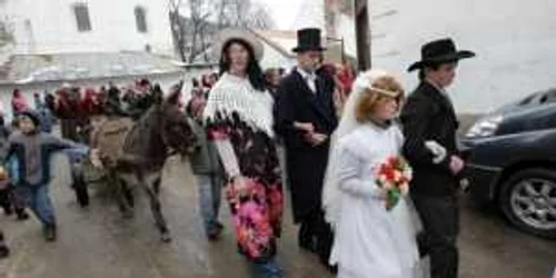 Sătenii adunaţi la porţile caselor cinstesc alaiul cu gogoşi şi sume de bani