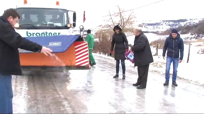 
    Şoferii au ajutat şi  au împrăştiat sare  înaintea utilajului Foto: www.citynews.ro  