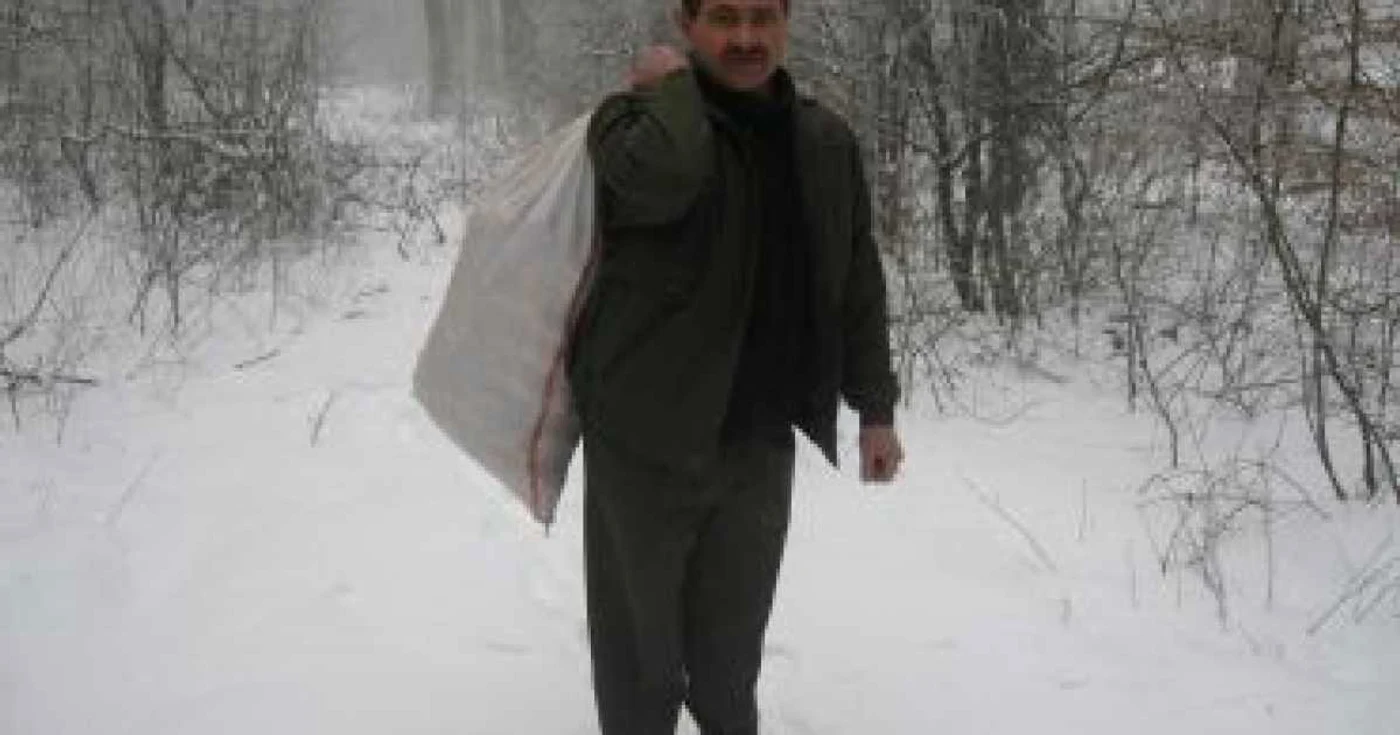 Ion Bălan cară hrana cu sacul prin pădure