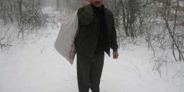 Ion Bălan cară hrana cu sacul prin pădure