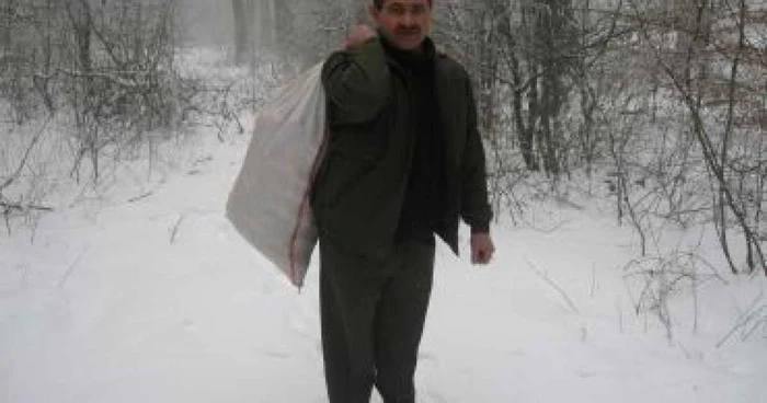 Ion Bălan cară hrana cu sacul prin pădure