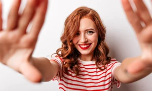 playful ginger girl posing with pleasure white wall stunning caucasian woman striped t shirt smiling jpg