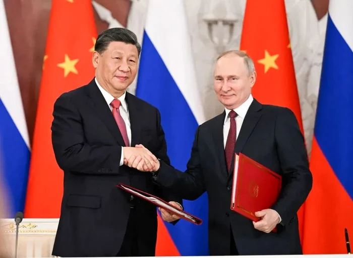 Strângerea de mână dintre Xi Jinping și Vladimir Putin după semnarea unor declarații comune