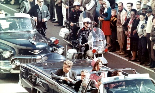 Președintele John F. Kennedy în limuzină, la Dallas, cu câteva minute înainte de asasinat (©  Wikimedia Commons)