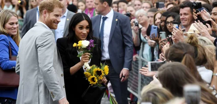 Ducesa Meghan Markle şi Prinţul Harry au petrecut 20 de minute doar pentru a-şi saluta fanii, care le-au oferit flori FOTO Guliver/Getty Images