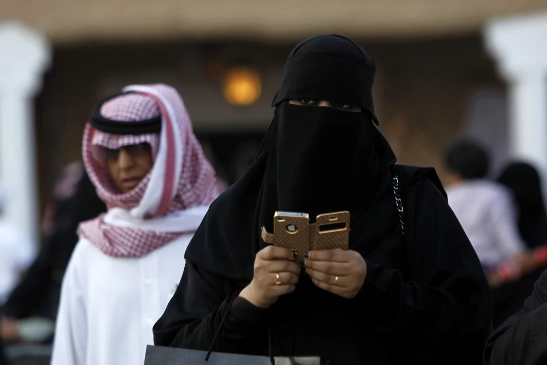 O imagine comună din capitala Arabiei Saudite, o femeie verificându-şi smartphone-ul- bogăţie fără evoluţie FOTO Reuters