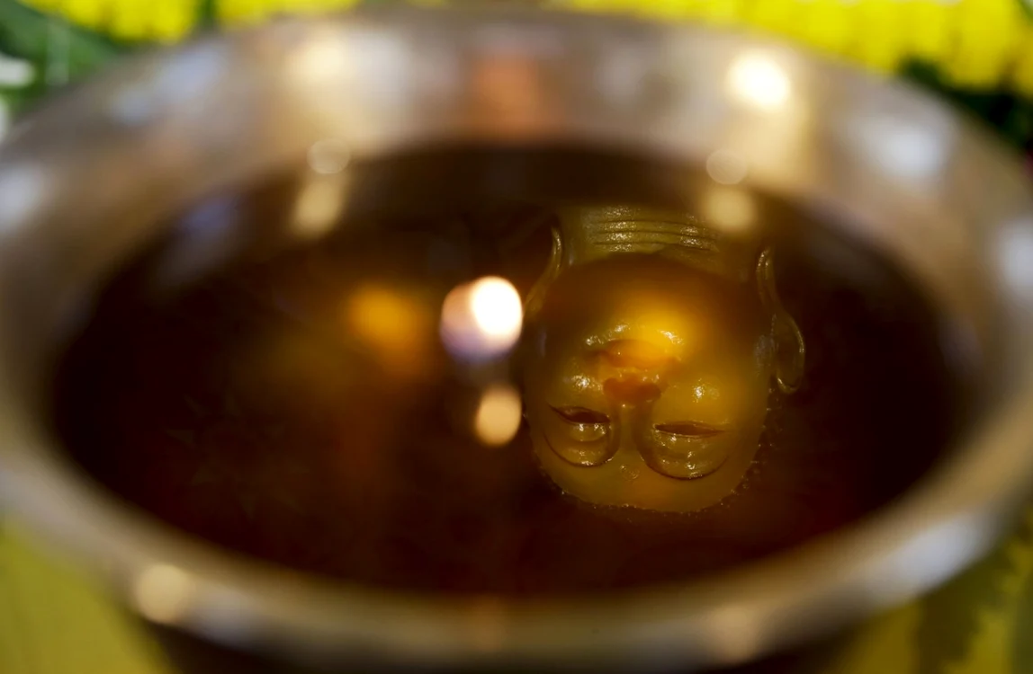 Imaginea lui Buddha este reflectată într-o lampă cu ulei la un templu în timpul sărbătorii Buddha Purnima în Kolkata India FOTO AP