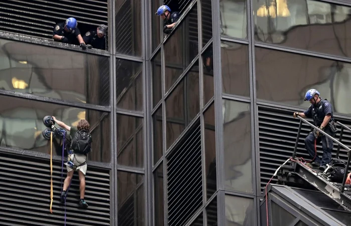 Un bărbat escaladează faţadă din sticlă a clădirii de 58 de etaje Trump Tower din New York FOTO AP / Julie Jacobson