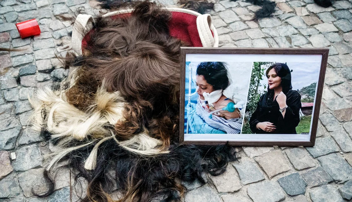 Păr uman și portrete ale lui Mahsa Amini.  Manifestație la Berlin Foto EPA EFE