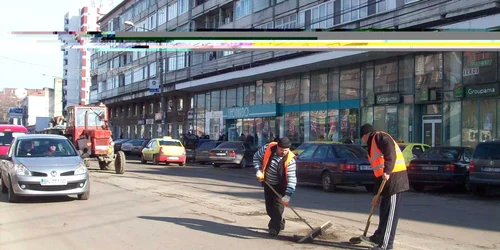 Lucrătorii au măturat gropile, ca să facă loc bitumului fierbinte