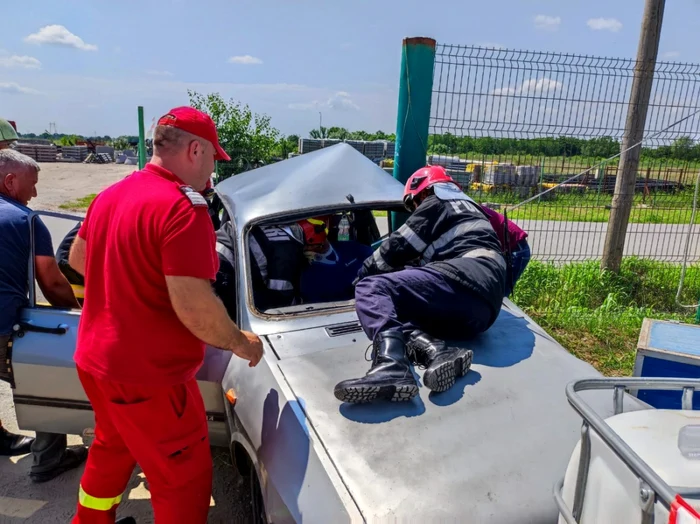 Pompierii intervint pentru a scoate din Dacia implicată în accident şoferul rănit FOTO ISU